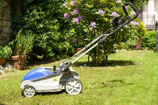 Blue Lawnmower in a garden during the work
