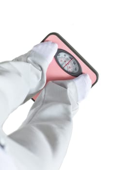 Young woman stands on scales and measures weight on a white background. Concept of healthy lifestyle.
