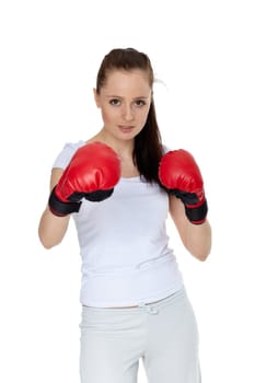 Sporty young woman in red fighting gloves on a white background.