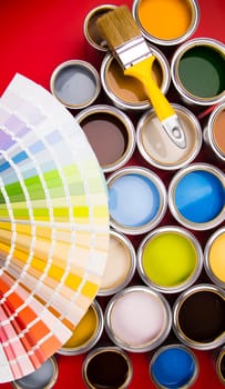 Full Buckets of rainbow colored oil paint on red background
