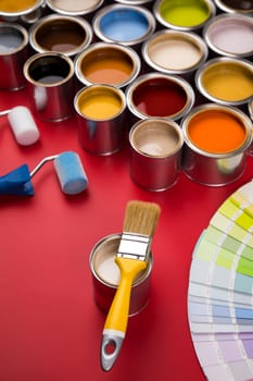 Full Buckets of rainbow colored oil paint on red background