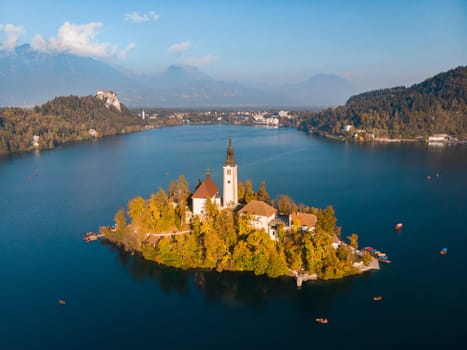 Aerial view of Bled island on lake Bled, and Bled castle and mountains in background, Slovenia, Europe.