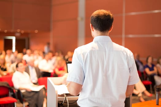 Academic professor lecturing at Conference. Audience at the lecture hall.