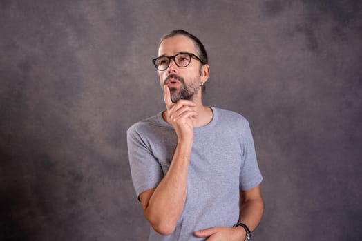 young bearded man with glasses is reflecting
