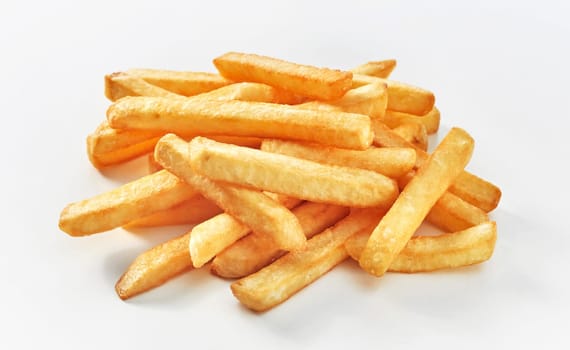 Stack of middle cut french fries on white background.