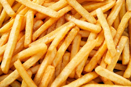 Fresh golden potato french fries in full frame, viewed from above in close-up. Fast food background concept