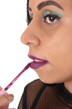 A close up image of the face of a beautiful young woman fixing up her.lips with nice makeup on her eye's, isolated for white background.