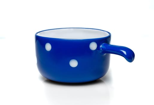 Blue cup with white polka dots on a white background