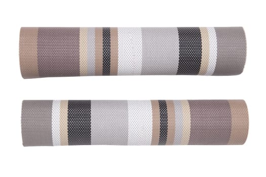 Plastic mats backgrounds. Two roles of woven plastic material with a colorful pattern isolated on a white background.