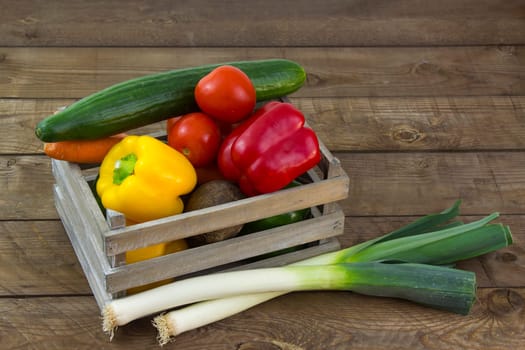 fresh vegetables in a box on wooden background
