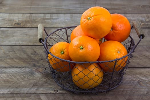 fresh oranges in a basket on wooden background