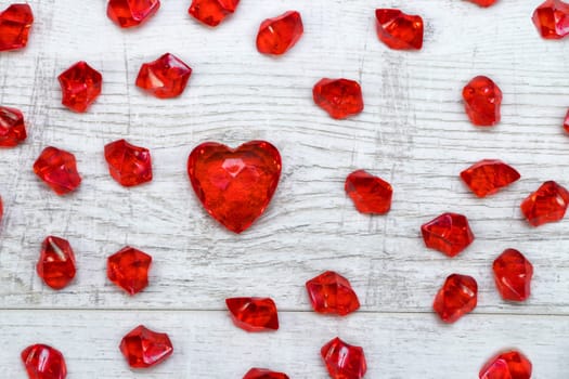 Red brilliant hearts on wooden background
