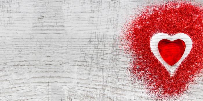 Heart shaped red sparkles on wooden background