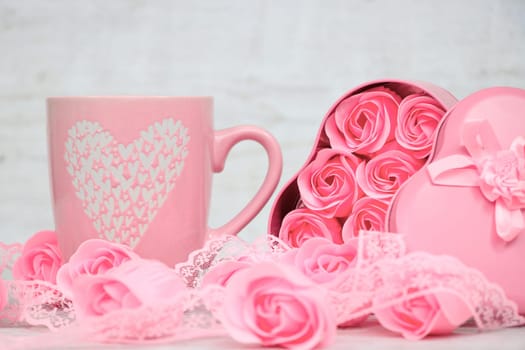 Pink porcelain coffee cup and pink heart roses