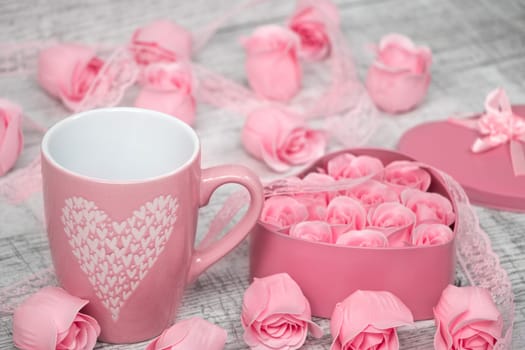 Pink porcelain coffee cup and pink heart roses