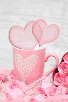 Pink porcelain coffee cup and pink heart roses