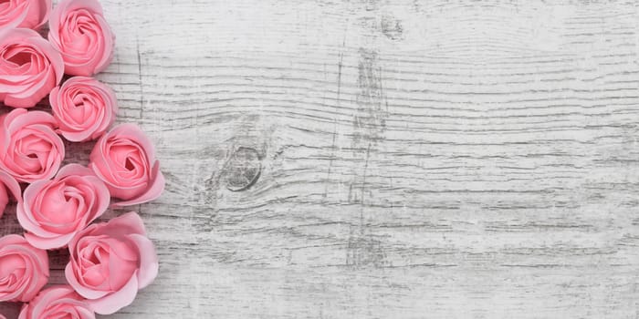 Pink roses on the wooden background