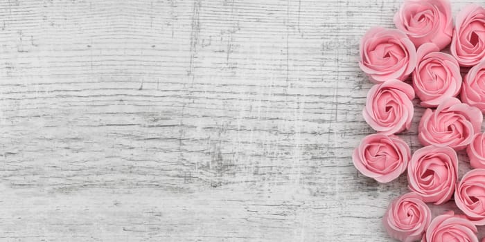 Pink roses on the wooden background