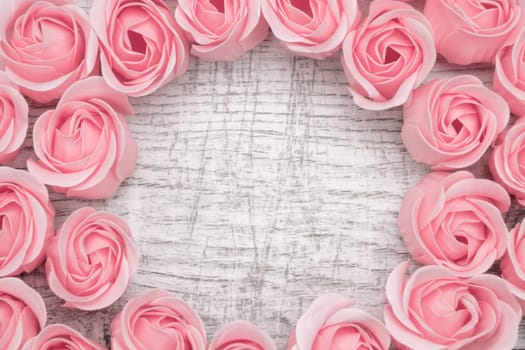 Pink roses on the wooden background