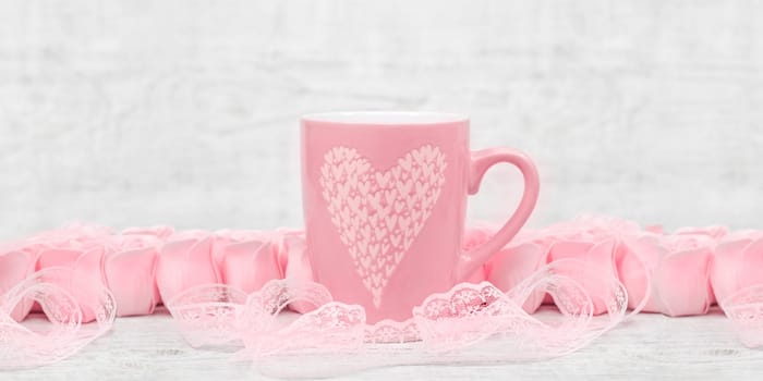 Pink porcelain coffee cup and pink heart roses