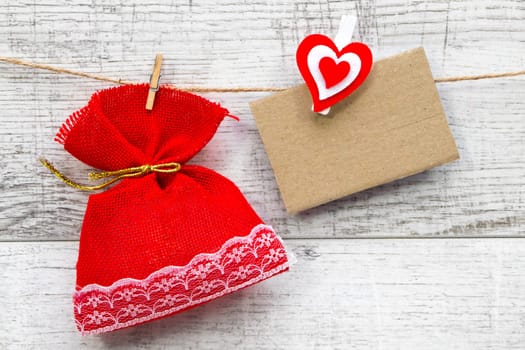 Gift sack with heart note in wooden background