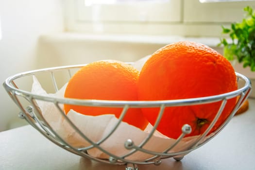 a couple of oranges in a metal basket. Healthy food. Citrus fruits