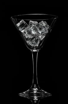Glass wine glass with ice on a black background