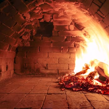 Fire wood burning in an old oven ready to cook