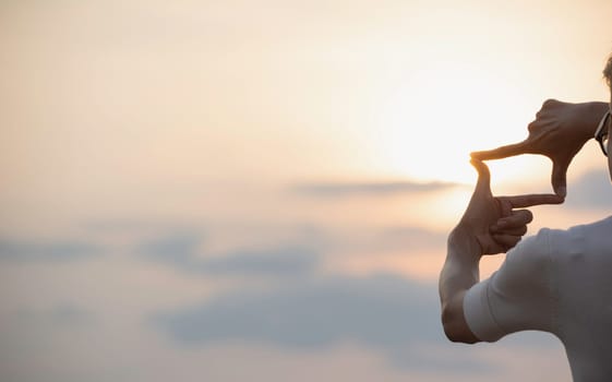 Hands making frame with sunset. Close up of woman hands making frame gesture.