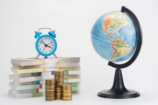 A stack of money worth hours, a stack of coins, a globe