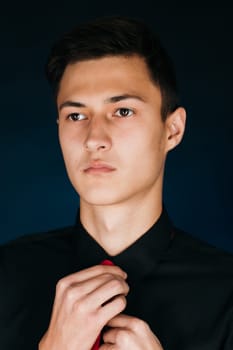 Portrait young guy on a dark studio.