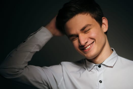 young brunette guy in a white shirt.