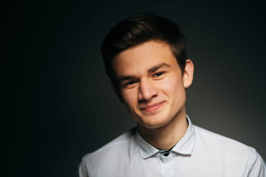 young brunette guy in a white shirt.