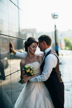 Wedding couple on backround mirror buildings.