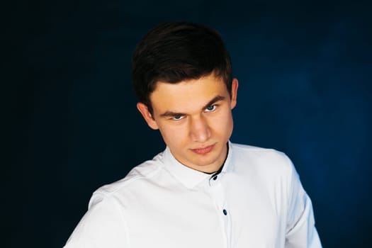 young brunette guy in a white shirt.