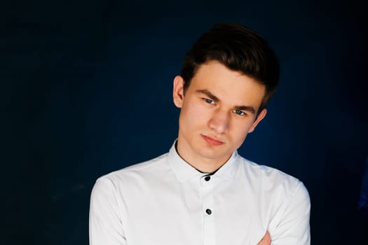 young brunette guy in a white shirt.