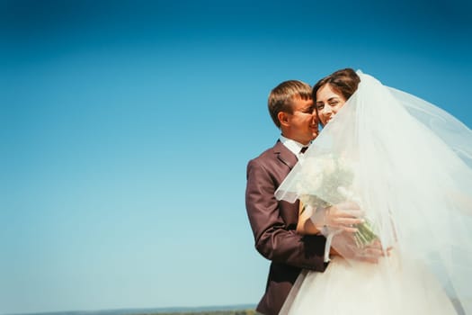 young bride and groom couple on the sky background.