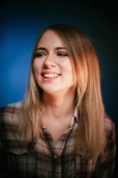 portrait smiling girl on blue background in studio.