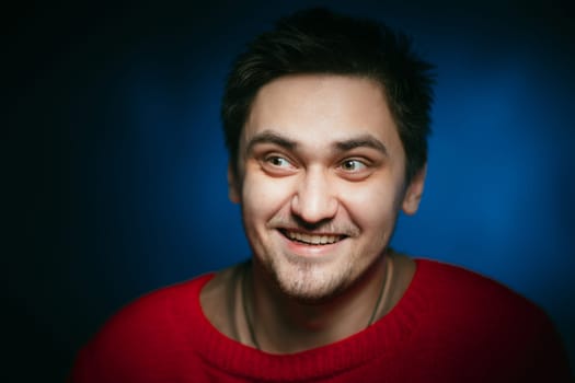emotional young man photo in studio on blue background
