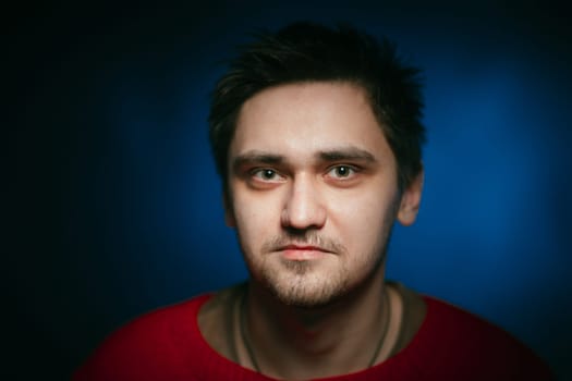emotional young man photo in studio on blue background