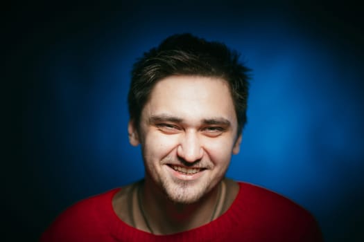 emotional young man photo in studio on blue background