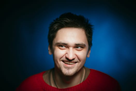 emotional young man photo in studio on blue background