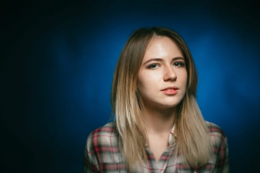 portrait smiling girl on blue background in studio.