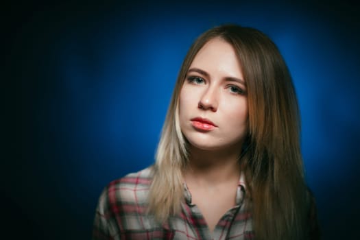 portrait smiling girl on blue background in studio.