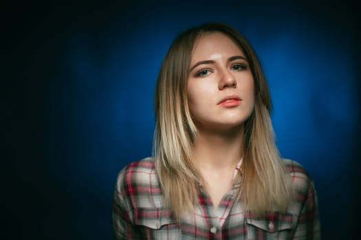 portrait smiling girl on blue background in studio.