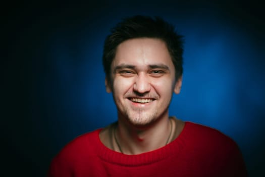 emotional young man photo in studio on blue background