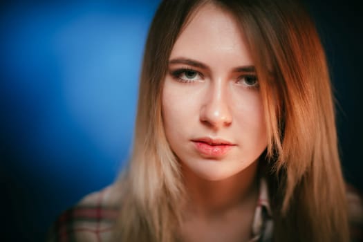 portrait smiling girl on blue background in studio.