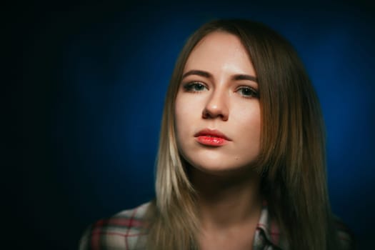 portrait smiling girl on blue background in studio.
