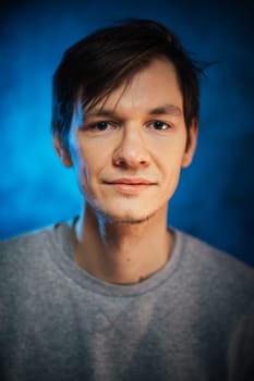 portrait emotional young man on blue background.