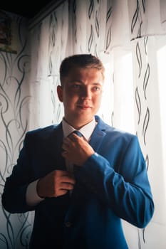 portrait of the groom on a light background.